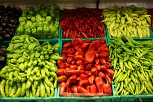 Verschillende soorten pepers in bakken op een markt