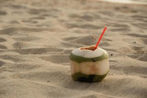 kokos met rietje op strand