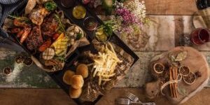 christmas-wallpaper-2009590_1280-300×169-1 Gevarieerd en kleurrijk diner met vlees, gegrilde groenten, friet en broodjes, typerend voor de moderne foodsector.