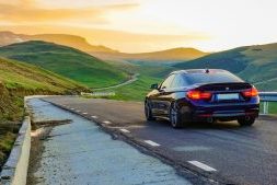 Auto rijdt bij zonsondergang over een rustige bergweg – voorbereiding autorit in praktijk