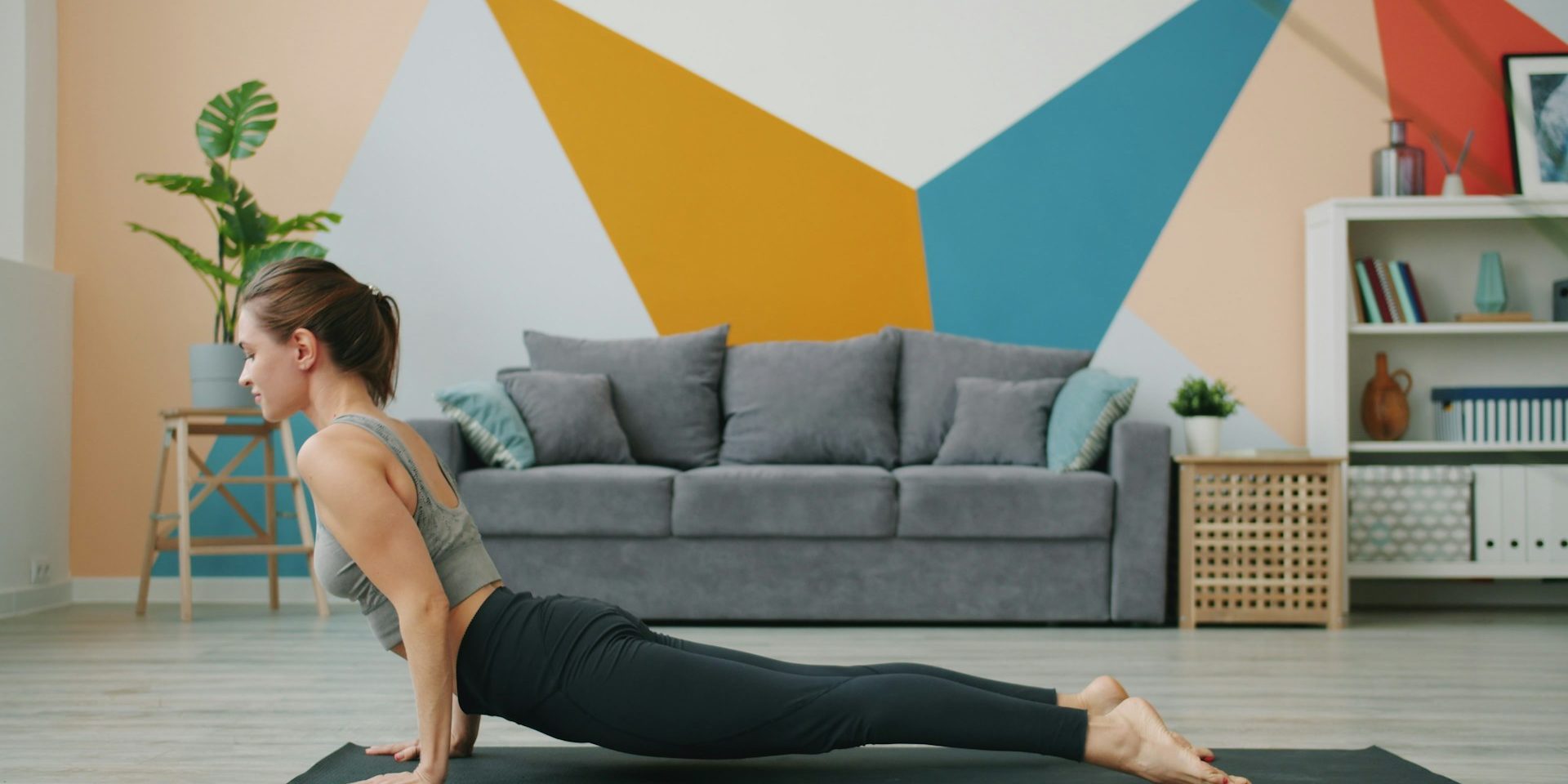 Vrouw luistert naar haar lichaam tijdens yoga in een rustige woonruimte