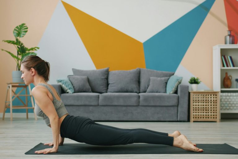 Vrouw luistert naar haar lichaam tijdens yoga in een rustige woonruimte