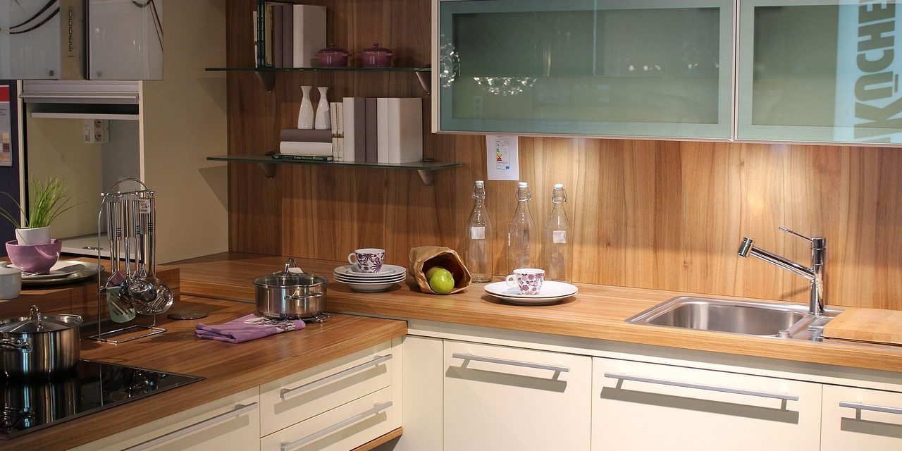 Moderne keuken met houten werkblad, pannen op de kookplaat en accessoires die bijdragen aan brandwonden voorkomen.