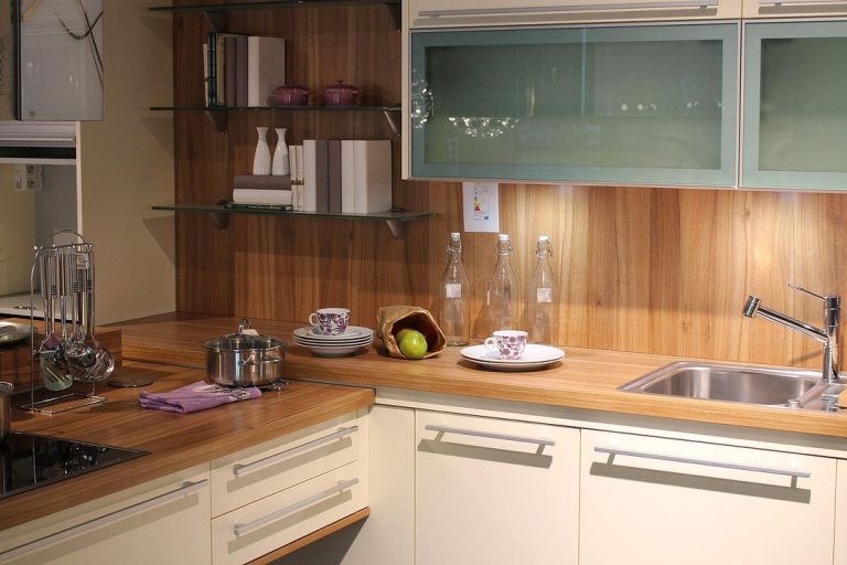 Moderne keuken met houten werkblad, pannen op de kookplaat en accessoires die bijdragen aan brandwonden voorkomen.