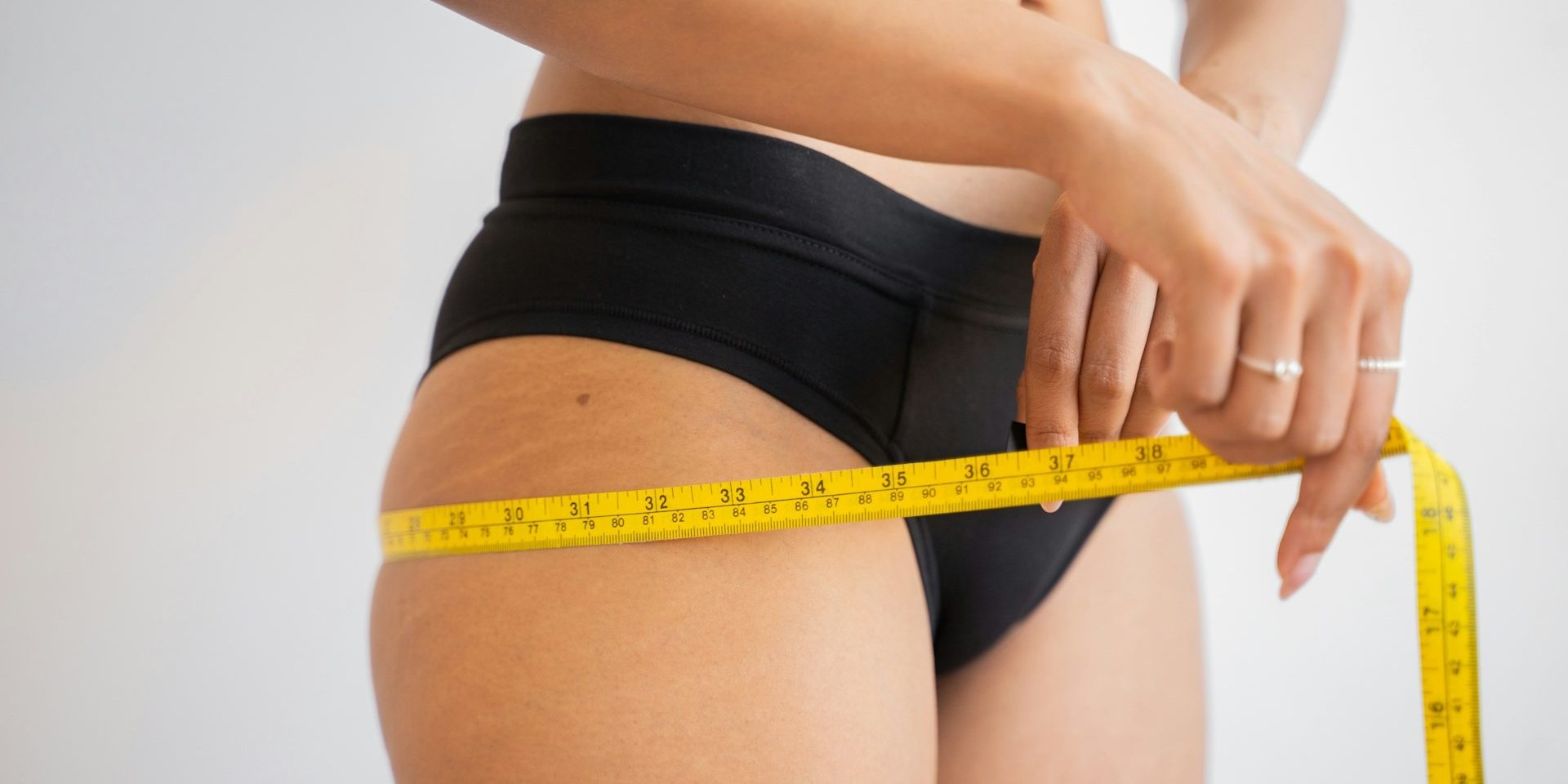 Persoon meet dijomvang met meetlint als onderdeel van een traject voor medisch afvallen