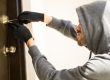 Inbreker probeert slot open te maken wat inbraak impact op veiligheid en vertrouwen laat zien