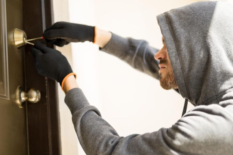 Inbreker probeert slot open te maken wat inbraak impact op veiligheid en vertrouwen laat zien