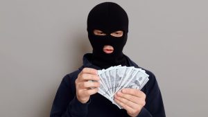 Persoon met bivakmuts telt geld na inbraak impact op gevoel van veiligheid