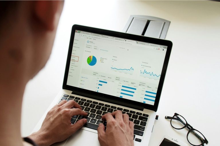 Persoon werkt op laptop met financiële data om overzicht te krijgen en financiële stress te verminderen