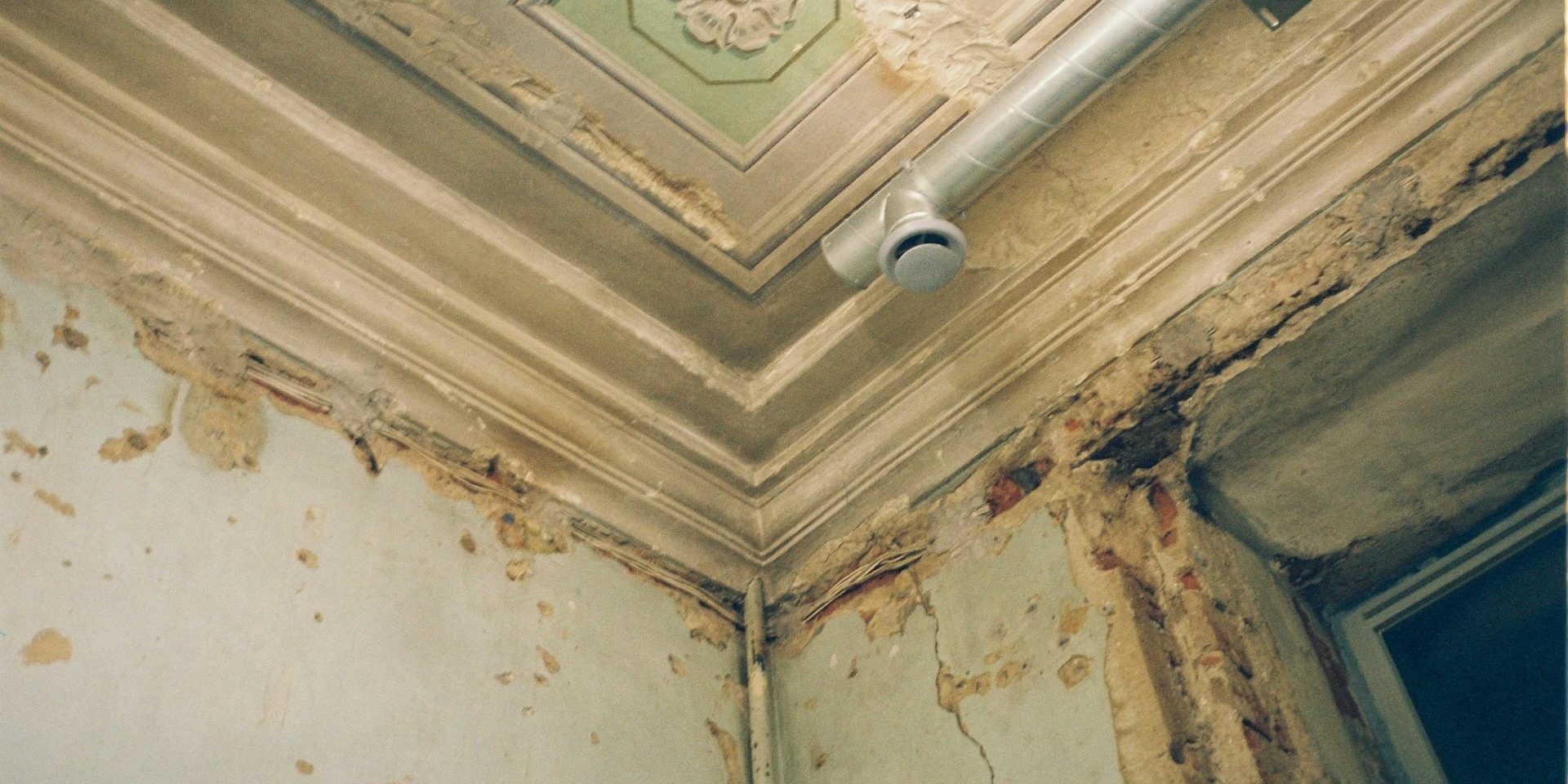 Vochtproblemen schimmel zichtbaar op beschadigde muur en plafond door lekkage in oude woning