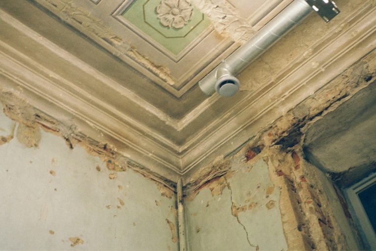 Vochtproblemen schimmel zichtbaar op beschadigde muur en plafond door lekkage in oude woning