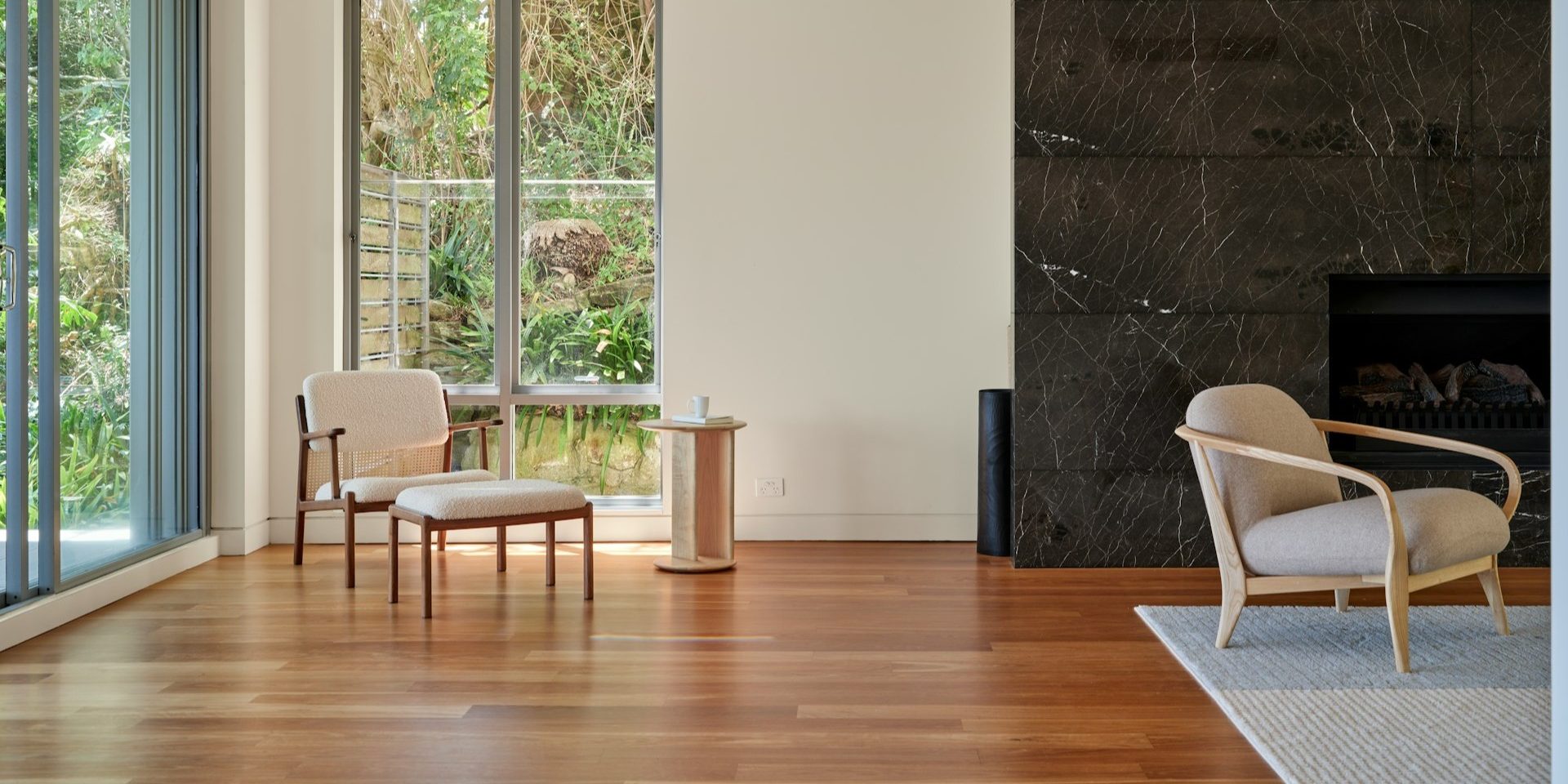 Moderne woonkamer met houten vloer bij allergie, grote ramen, lichte stoelen en klein vloerkleed