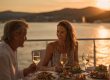 Stel geniet van een maaltijd tijdens een Dinner cruise op het water bij zonsondergang.
