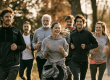 Groep van zes volwassenen die samen hardloopt in een park, een voorbeeld van sporten in groepsverband