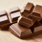Blokjes melkchocolade op een houten tafel